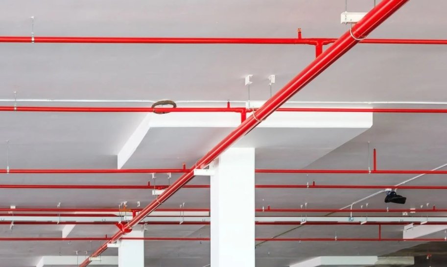 Red automatic sprinkler pipe network installed across a building ceiling