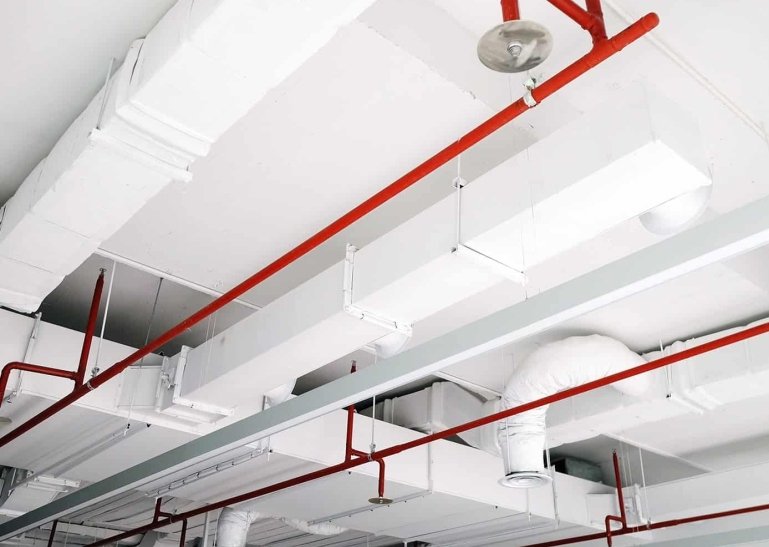 Automatic fire sprinkler piping coordinated with ceiling services